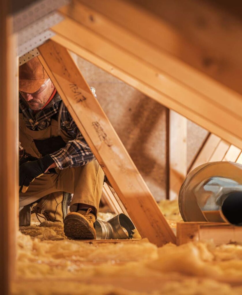 construction worker and attic workspace with HVAC system